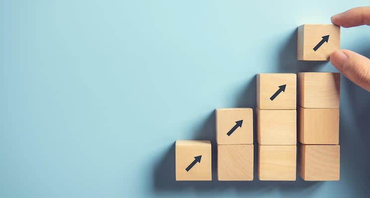 Hand arranging wood block stacking as step stair on paper pink background. Business concept growth success process, copy space.
