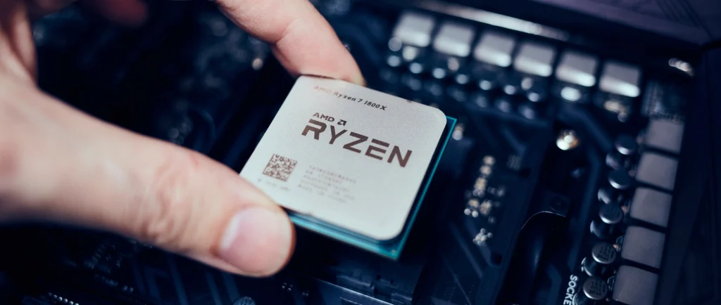 A hand, holding the AMD Ryzen chip.