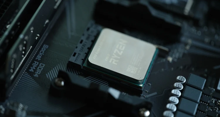 Close-up of an AMD Ryzen processor installed in a motherboard socket, surrounded by various electronic components. The image highlights the CPU's positioning and integration within a high-performance PC build.