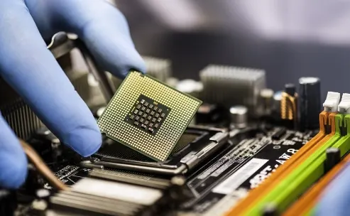 a hand lifting an intel chip with thumb and index finger